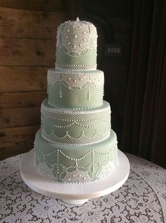 a three tiered wedding cake sitting on top of a white doily covered table