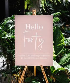 a sign that says hello forty on it in front of some green plants and trees