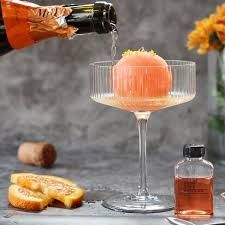 someone pouring wine into a glass with orange slices