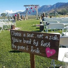 a sign that says choose a seat not a side you're loved by both the groom and bride