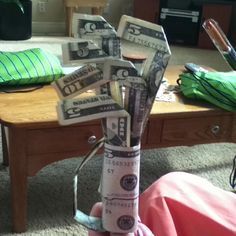 a person holding money in their hand on the floor next to a coffee table and couch