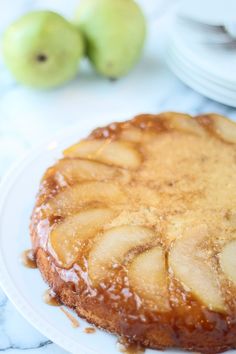 a close up of a cake on a plate with caramel sauce and sliced apples