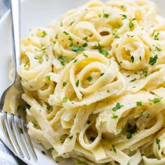 a white plate topped with pasta and parsley