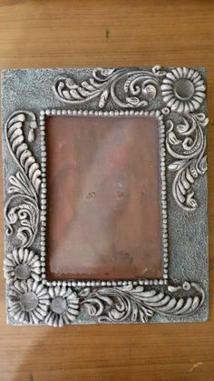 an ornate silver frame on a wooden table