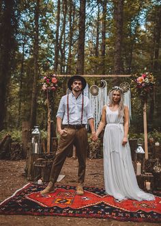 a man and woman standing in front of a wedding arch