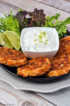 crab cakes on a plate with sour cream and lettuce