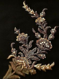 an embroidered gold floral design on a black background