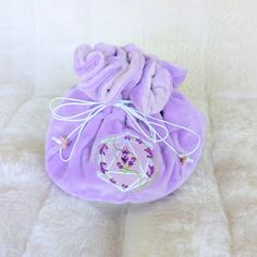 This lavender multi pocket dice bag is made with two shades of purple plush fabric. It is soft to the touch and will keep your dice nice and cozy. The embroidered design on the front features a D20 with swirling blooms of lavender surrounding it. The bag has strong cord drawstrings accented with purple butterfly charms at the ends.  Inner bag space is about 9 x 4.5 inches, plenty of room for several sets of dice, there are 6 inner pockets that will hold 3 to 4 standard dice sets and 1 large midd Purple Embroidered Bag For Gift, Purple Dice, Dice Storage, Purple Bag, Dice Bag, Plush Fabric, Purple Butterfly, Butterfly Charm, Embroidered Design