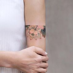 a woman's arm with a flower tattoo on the left side of her arm