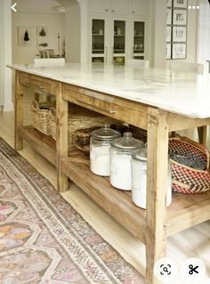 a kitchen island with jars and baskets on it