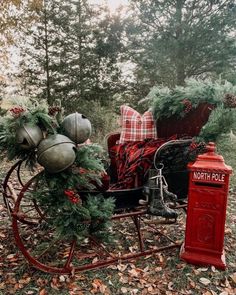 a horse drawn carriage with christmas decorations on it's front and back wheels in the woods