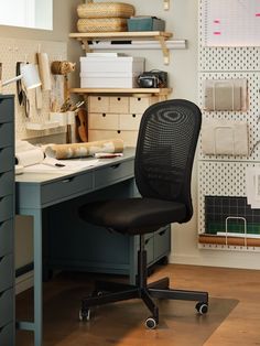 an office chair sitting in front of a desk with drawers and shelves on the wall