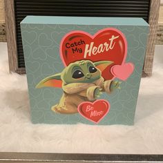 a card with an image of a baby yoda holding a heart