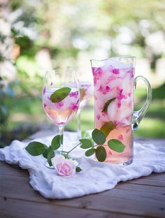 two glasses filled with water and pink flowers