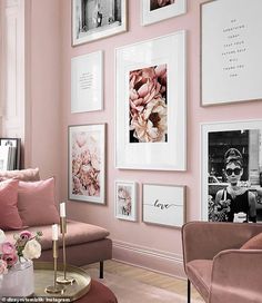 a living room with pink walls and pictures on the wall