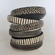 four black and white plates stacked on top of each other in the shape of circles