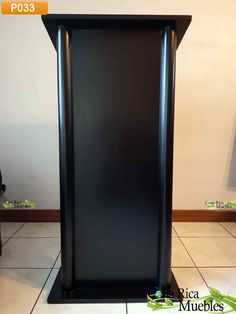 a tall black cabinet sitting on top of a tiled floor