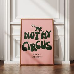 a pink poster with the words not my circus written on it in green lettering, against a white wall