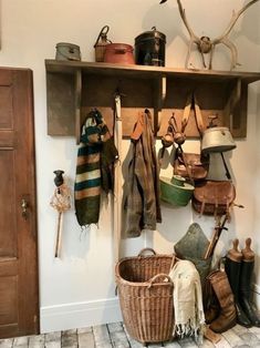 a wooden shelf filled with lots of hats and other items next to a door in a room