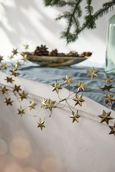 some gold stars are hanging from the ceiling next to a glass vase and plate with food on it