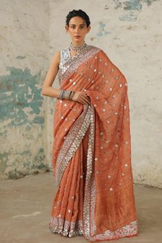 Rust handcrafted handwoven tusser silk saree with statement border in metallic silver floral, applique, aari and zardozi hand embroidery. Comes with matching plain unstitched blouse piece. - Aza Fashions Semi-stitched Cotton Silk Pre-draped Saree With Mirror Work, Unstitched Cotton Silk Saree With Mirror Work, Semi-stitched Cotton Silk Saree With Mirror Work, Cotton Silk Saree With Mirror Work For Eid, Eid Cotton Silk Blouse Piece With Mirror Work, Eid Cotton Silk Saree With Mirror Work, Eid Tussar Silk Traditional Wear With Mirror Work, Cotton Silk Blouse Piece With Mirror Work, Festive Tussar Silk Traditional Wear With Mirror Work