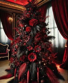 a red and black christmas tree decorated with flowers, feathers and ornaments in a fancy room