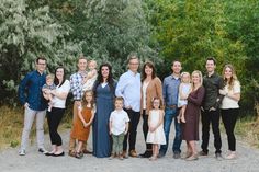 a group of people standing next to each other on a dirt road near trees and bushes