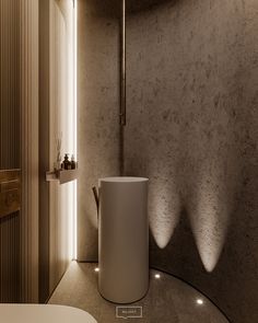 a bathroom with a round sink next to a wall mounted shower head and light fixture