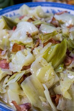 a blue and white plate topped with cabbage and bacon