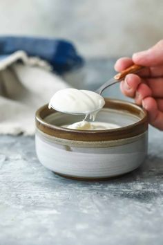 a person is spooning cream into a bowl