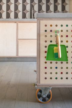 a green toothbrush holder on wheels in a kitchen