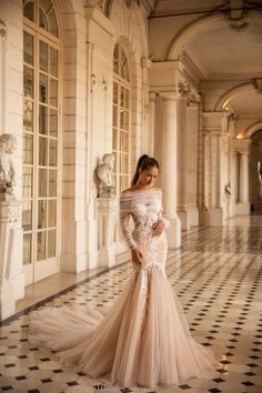 a woman in a wedding dress posing for the camera with her hands on her hips