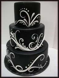 a three tiered black and white cake with swirls on it's sides