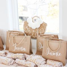 three bags sitting on top of a window sill next to some blankets and pillows