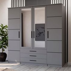 a large gray cabinet with mirrored doors and drawers in a living room area next to a potted plant