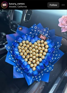 a heart made out of chocolates and blue ribbon in the back seat of a car