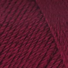 red skeins of yarn are shown in this close up photo, with the end of