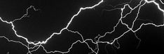 lightning strikes across the night sky in black and white