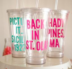 three plastic cups with pink and green lettering on them