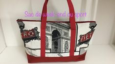 a red and white tote bag sitting on top of a counter next to a wall