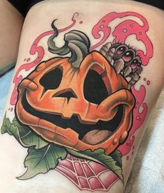 a woman's thigh with a pumpkin tattoo on it