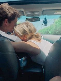 a man and woman are sitting in the back seat of a car, facing each other