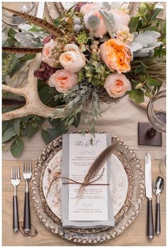 an image of a table setting with flowers and antlers on the place settings for dinner