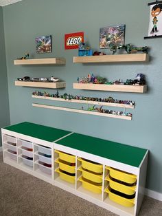 legos are lined up on the wall in this playroom with shelves and bins