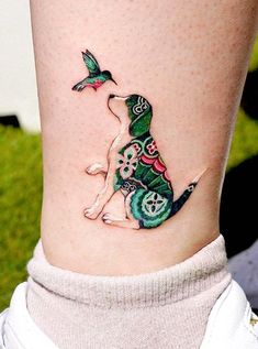 a small dog tattoo on the ankle with a bird flying over it's head