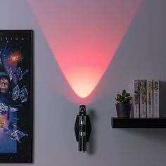 a star wars movie poster is on the wall next to a lamp and some books