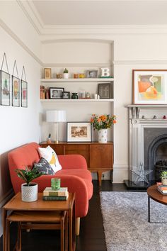 a living room filled with furniture and a fire place in the middle of it's wall