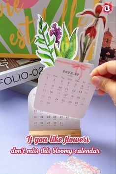 someone holding up a calendar with flowers on it and the words, if you like flowers don't miss this bloomy calendar