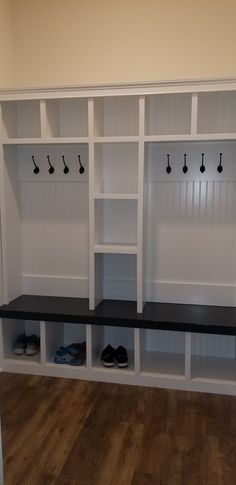 a room with some white shelves and black shoes