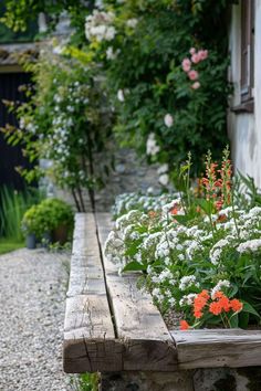 a wooden bench sitting next to a garden filled with flowers